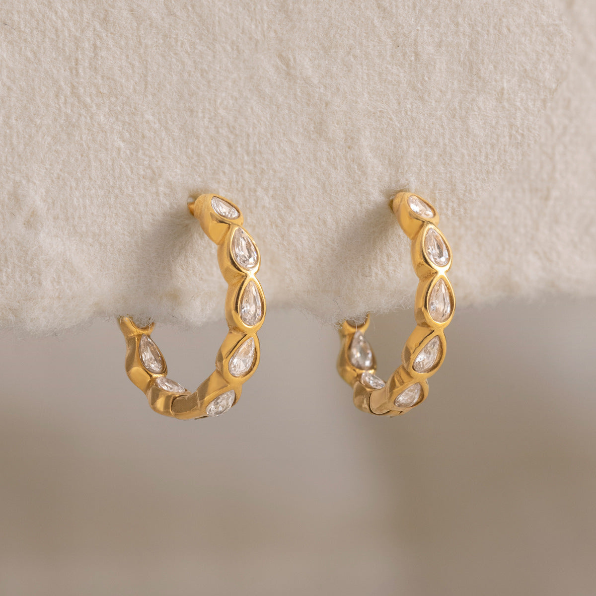 Albane teardrop hoops hanging from the edge of cream felt