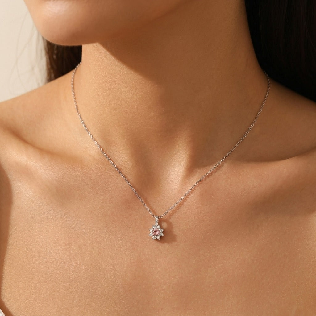 Woman wearing the Juliette Rosé crystal necklace, pink stone flower pendant on a silver chain