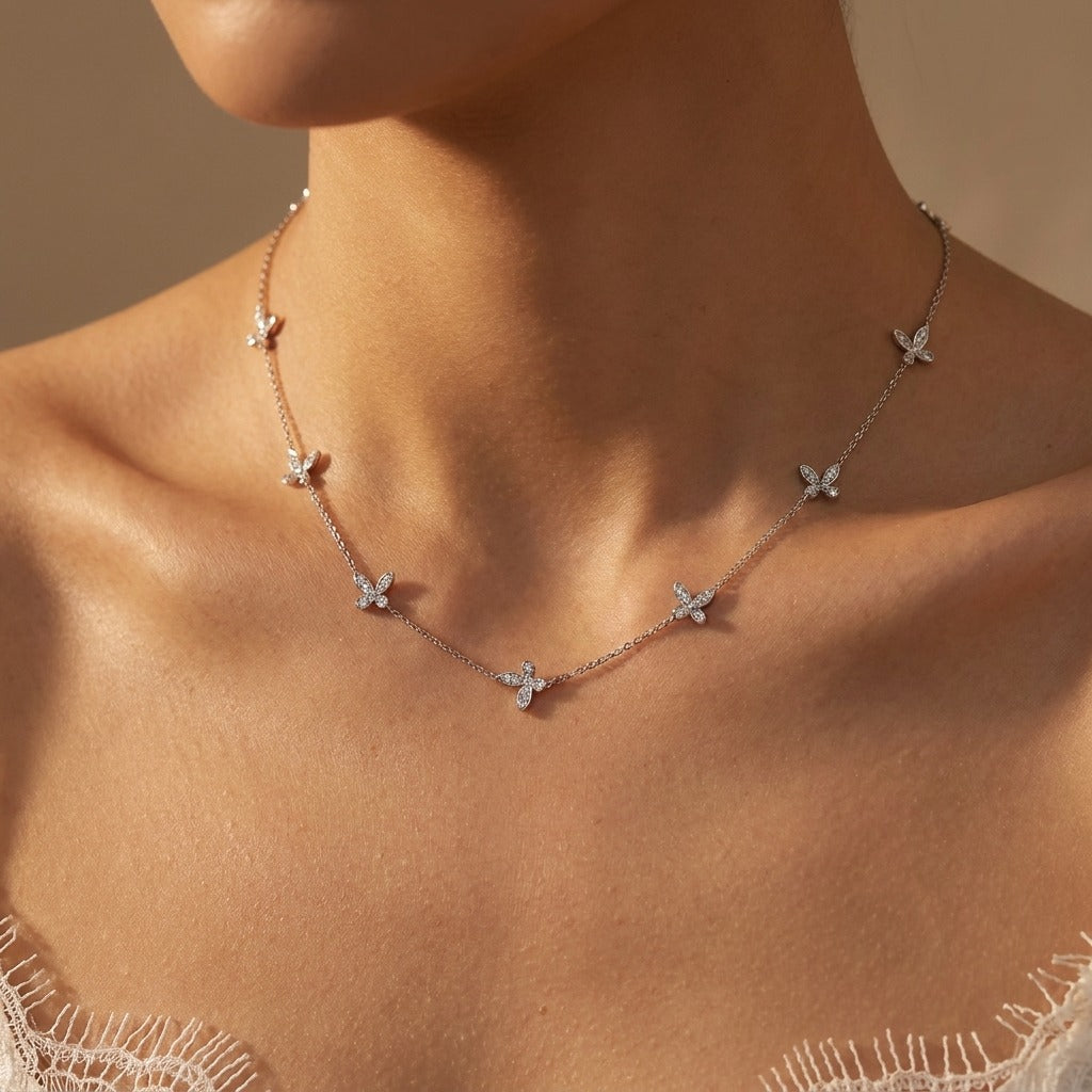 Woman wearing the Élodie butterfly necklace in silver with crystal butterflies spaced along the chain