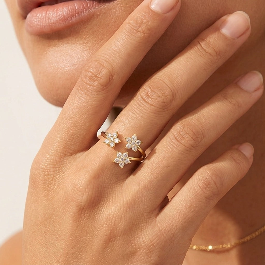Hand wearing the Lydia crystal flowers ring, an open gold band with three crystal flowers