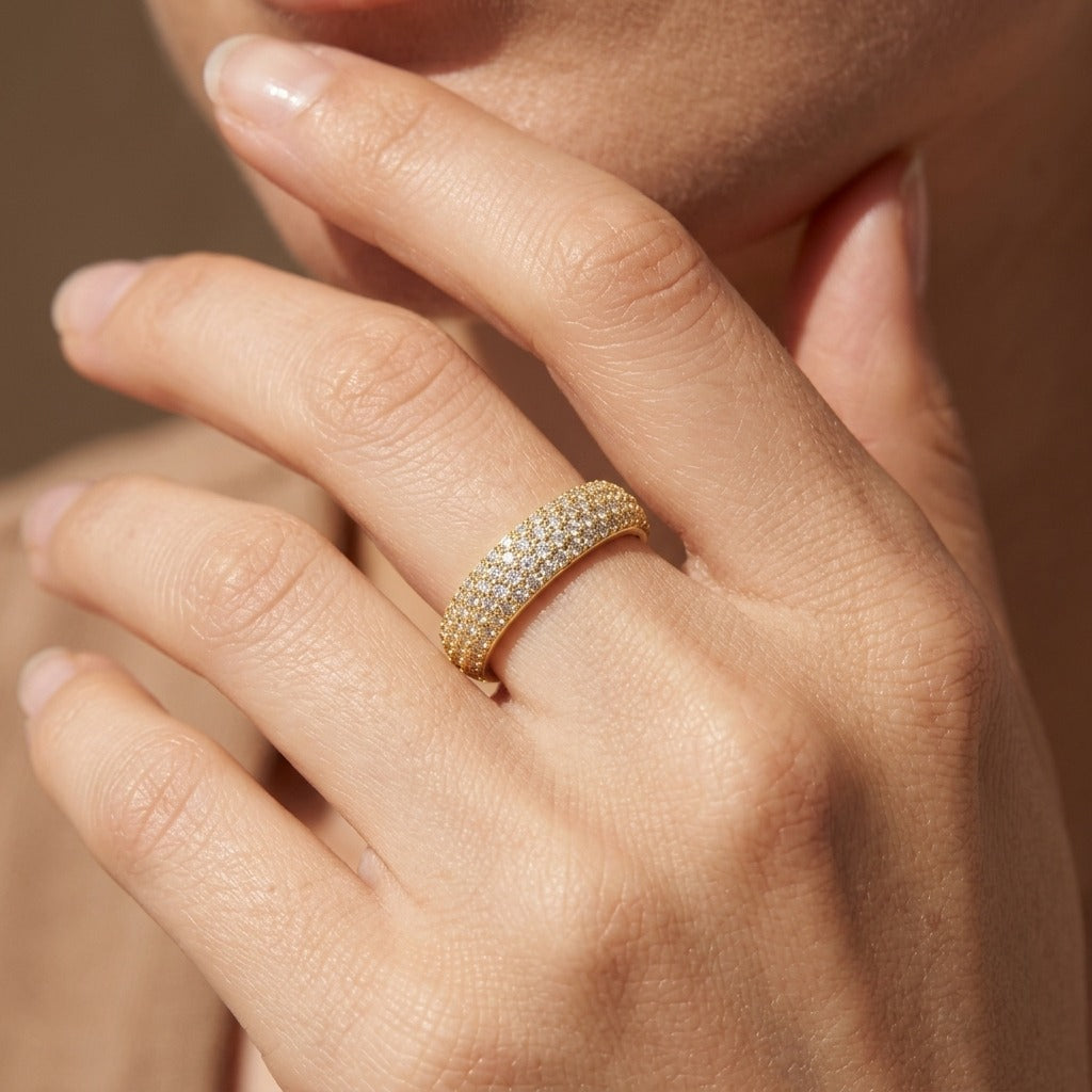 Woman wearing the Emilie luxe pavé ring in gold, a wide domed band covered in crystals