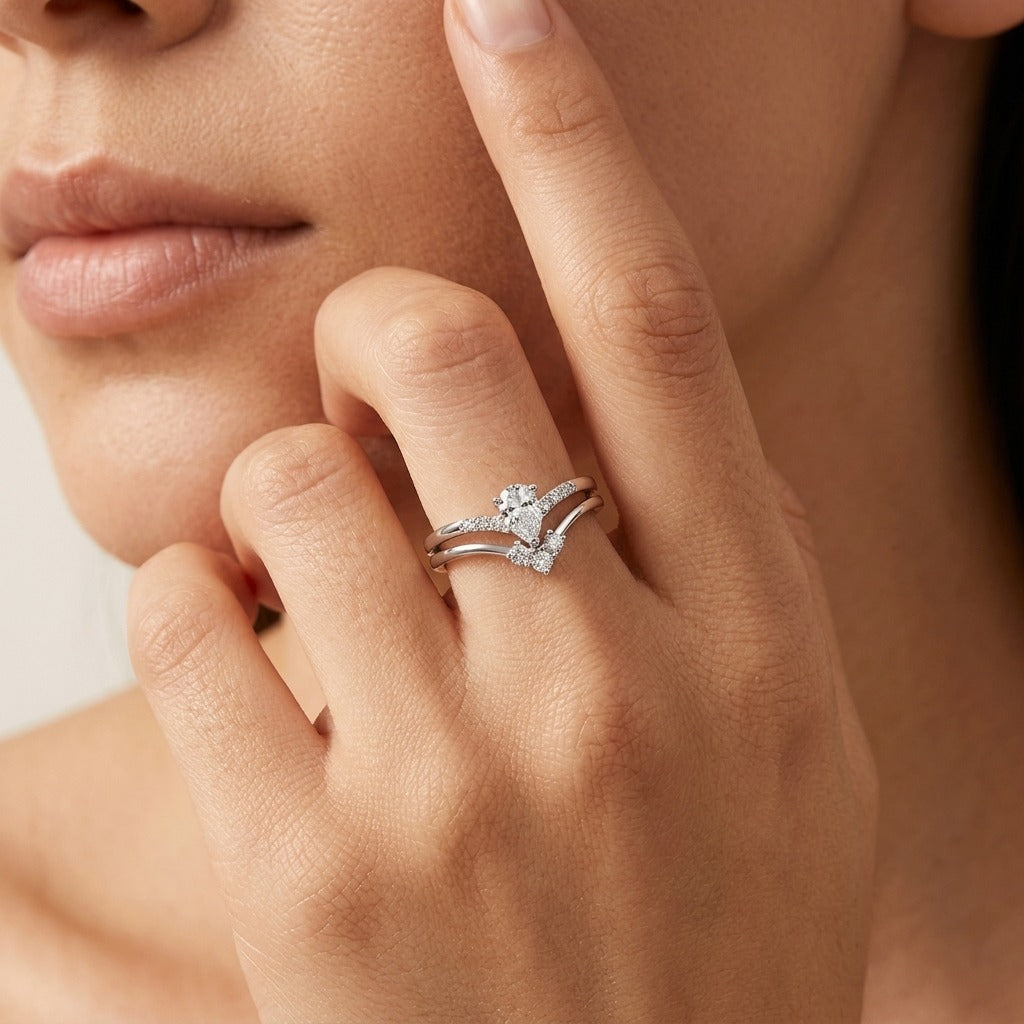 Hand wearing the Élodie crystal duo ring set in silver, a pear-cut stone band stacked with a V band