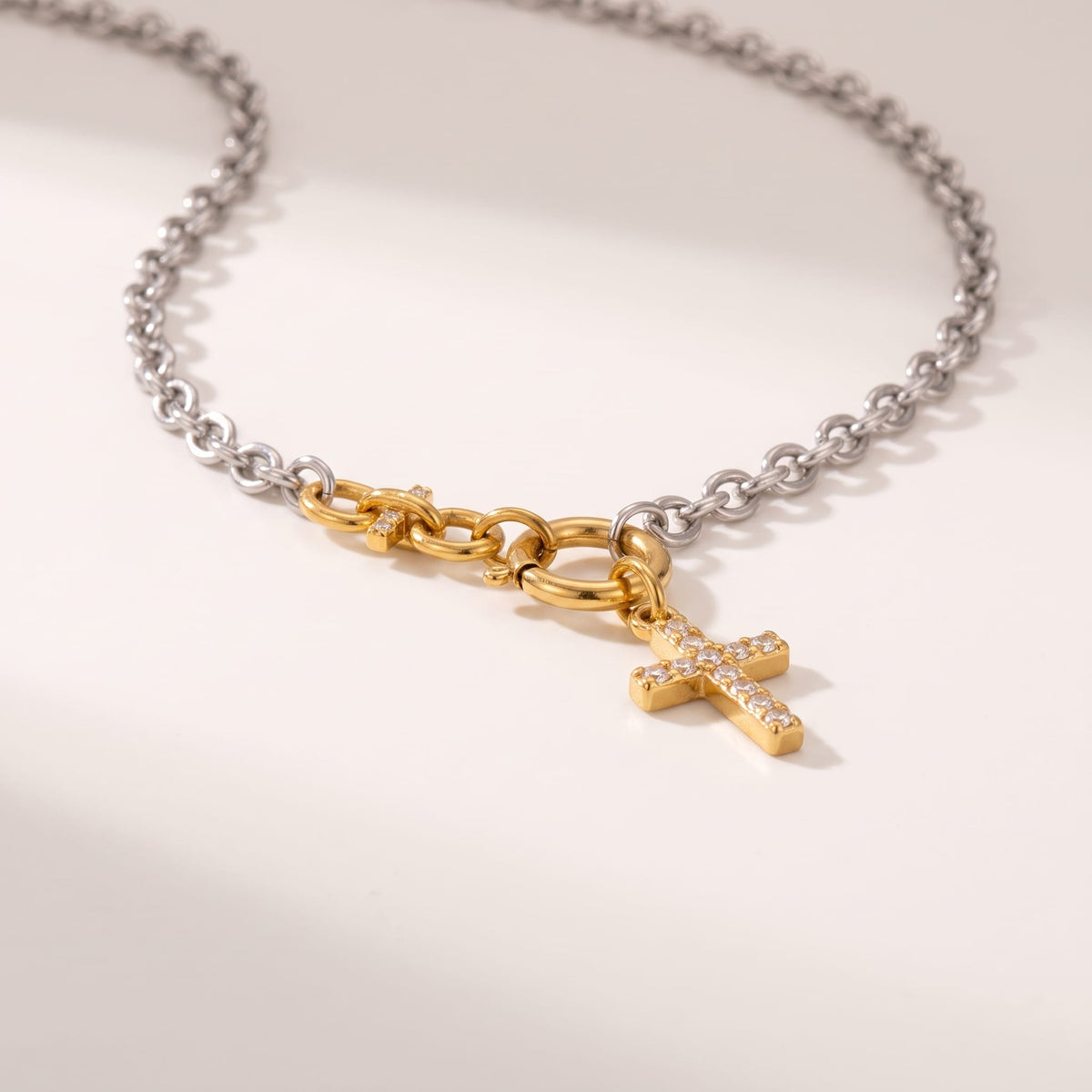 Eugénie cross charm two-tone necklace on a plain white surface showing the clasp and pendant detail