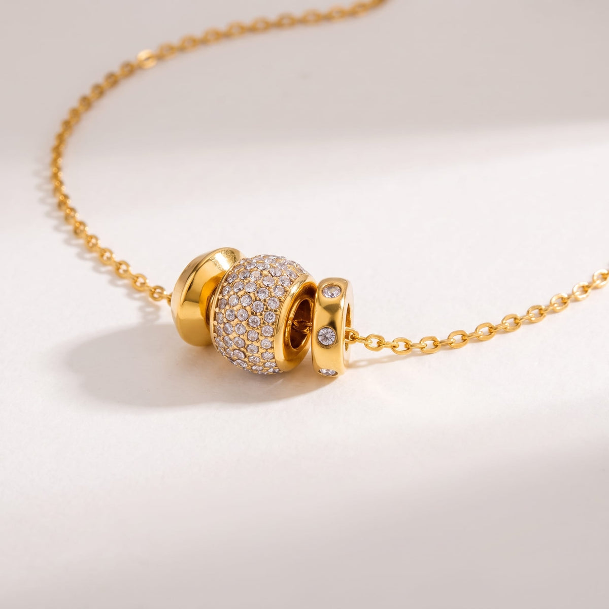 Fiona pavé rondelle gold necklace on a white surface with soft shadows