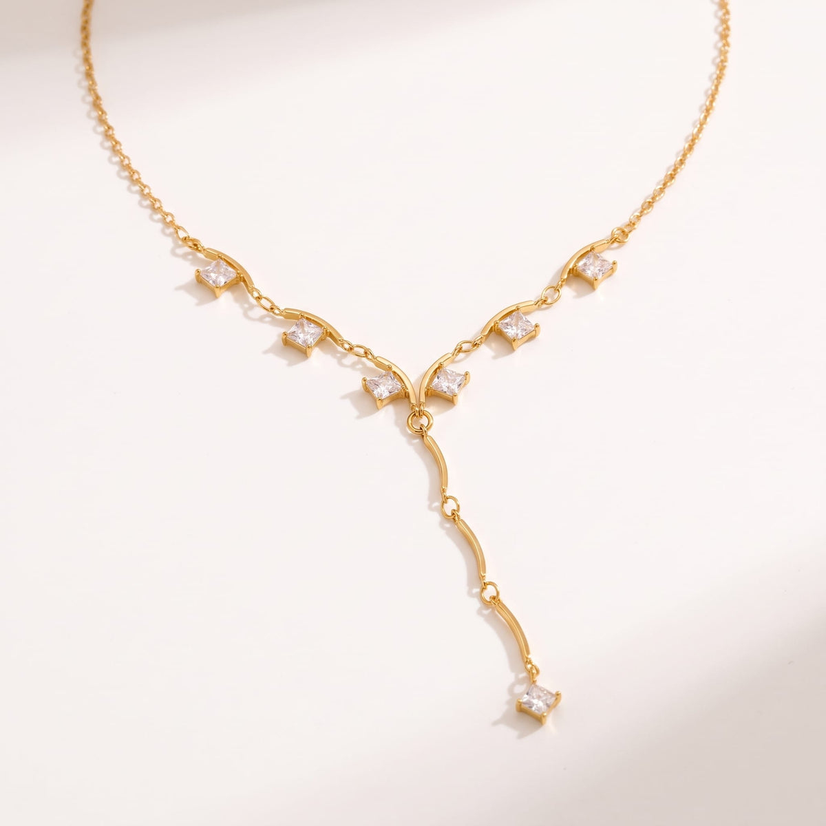 Gemma square crystal gold necklace on a plain white surface with soft shadows