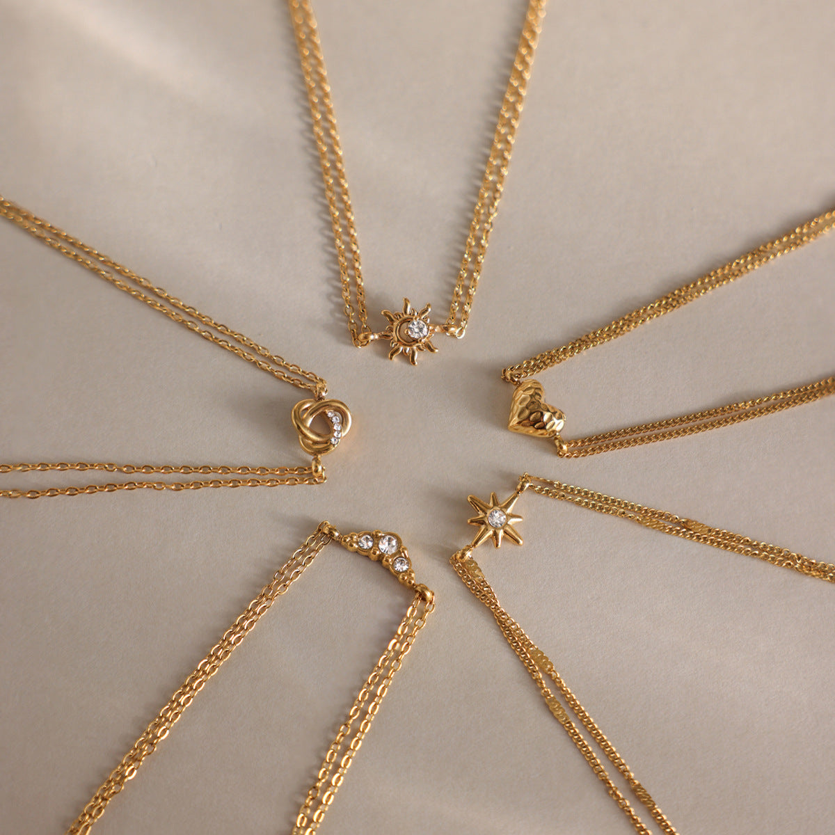 Juliette love knot bracelet in a star-shaped layout of five gold charm bracelets