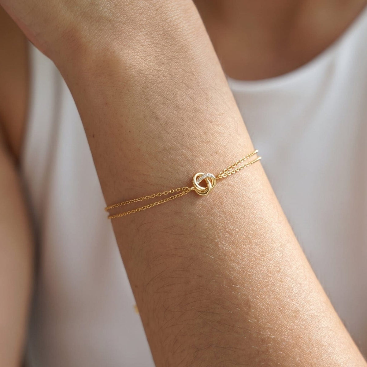 Woman wearing the Juliette love knot gold bracelet on the wrist