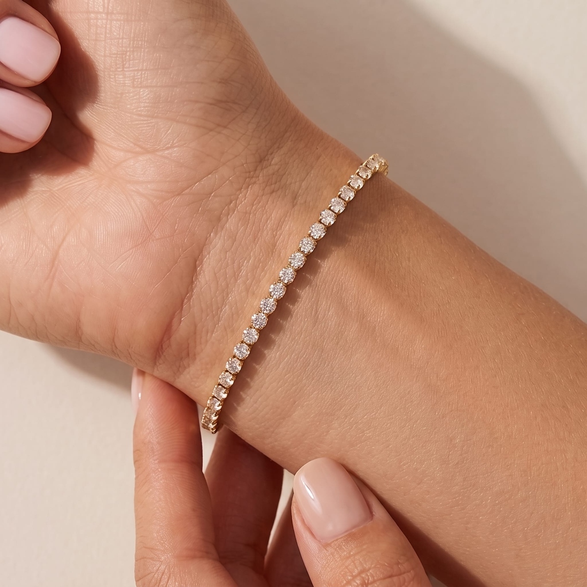 Woman wearing the Ottavia gold tennis bracelet, a single row of round crystals on the wrist