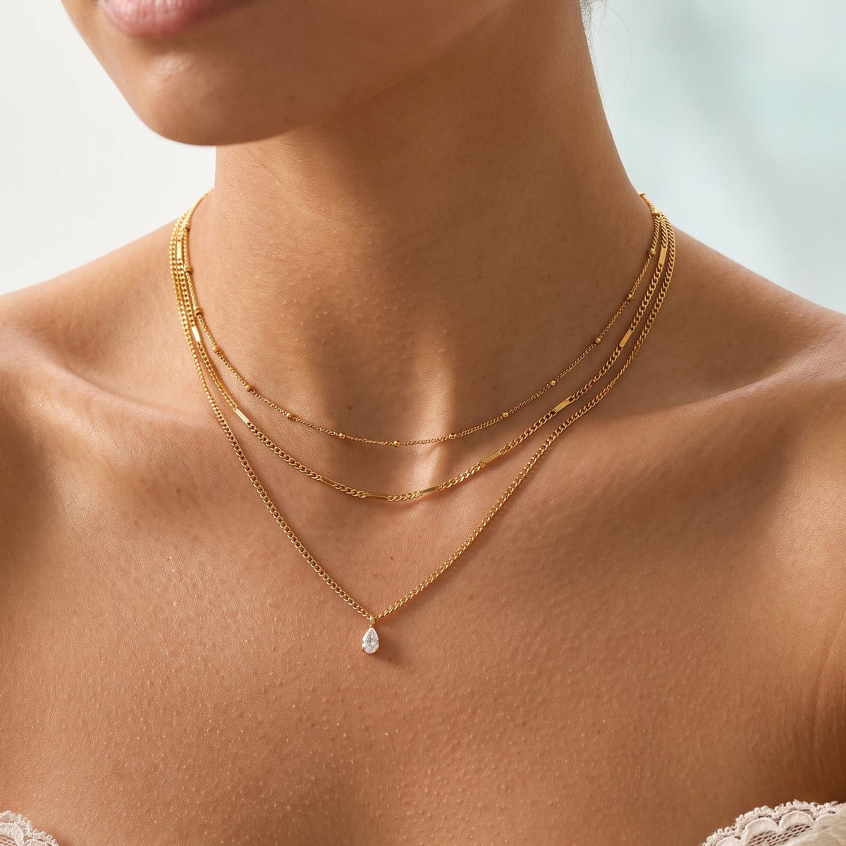 Woman wearing the Raphaëlle layered teardrop gold necklace at the collarbone