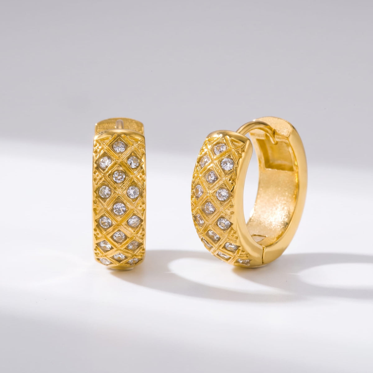 Solène lattice hoop gold earrings on a white surface with soft shadows