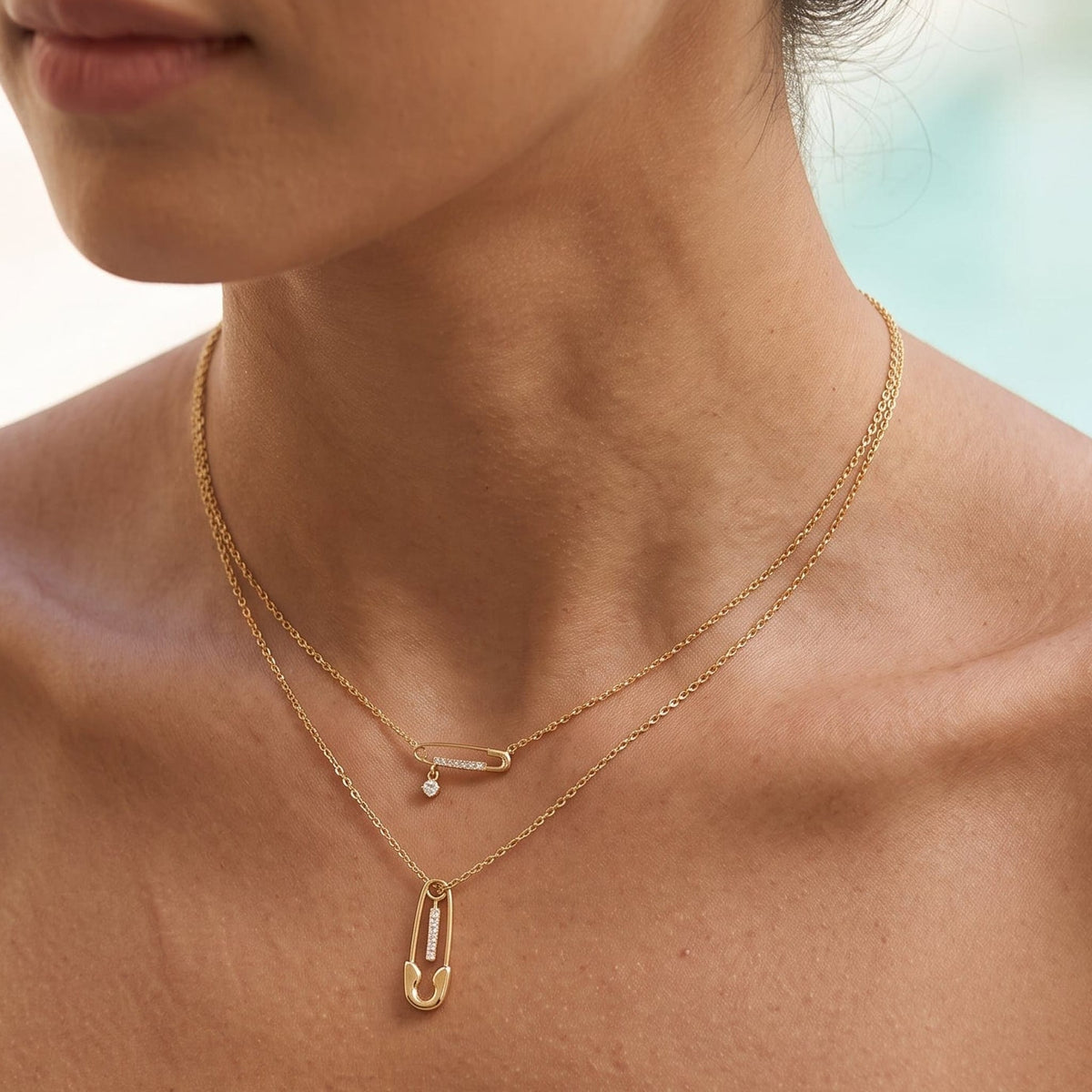 Woman wearing the Stella safety pin gold necklace at the collarbone