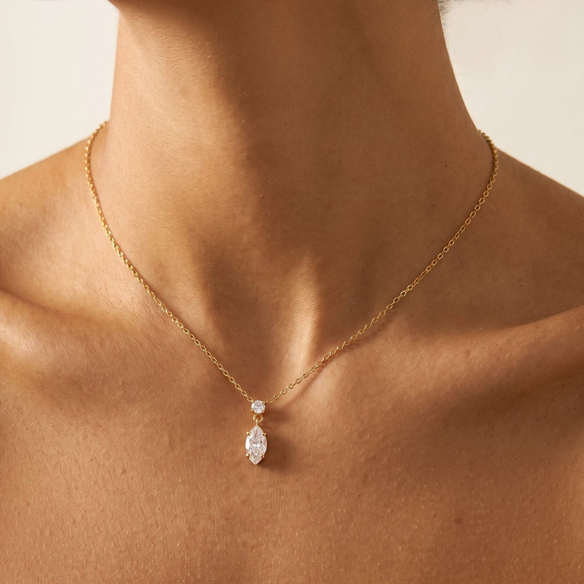 Woman wearing the Valentina marquise drop gold necklace at the collarbone