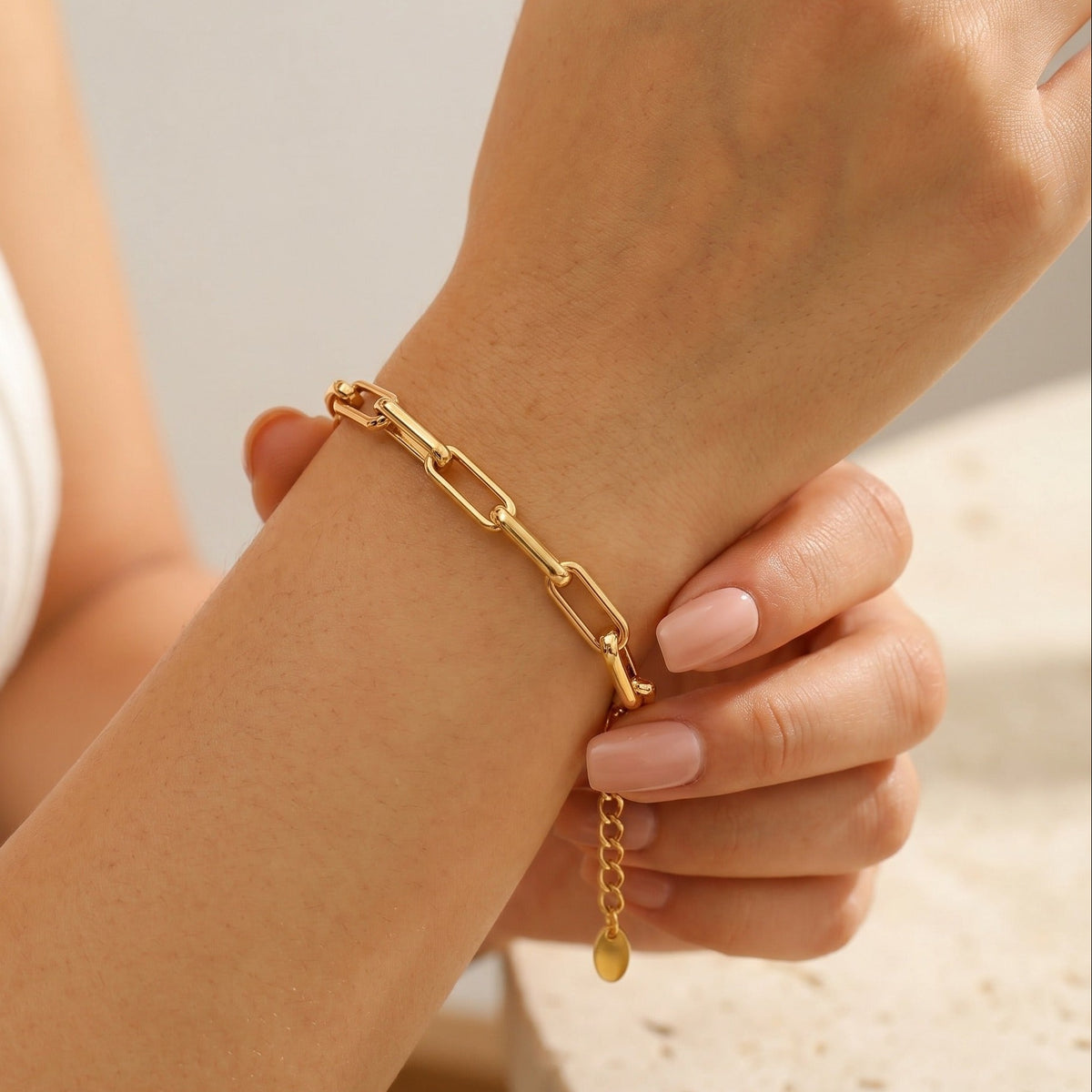 Woman wearing the Amélie gold link bracelet with long paperclip links and extender chain on the wrist