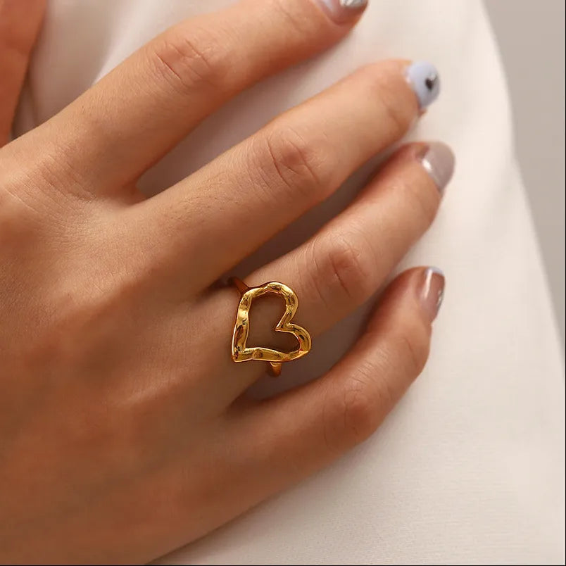 Woman wearing the Verity gold ring with an open hammered heart on her finger