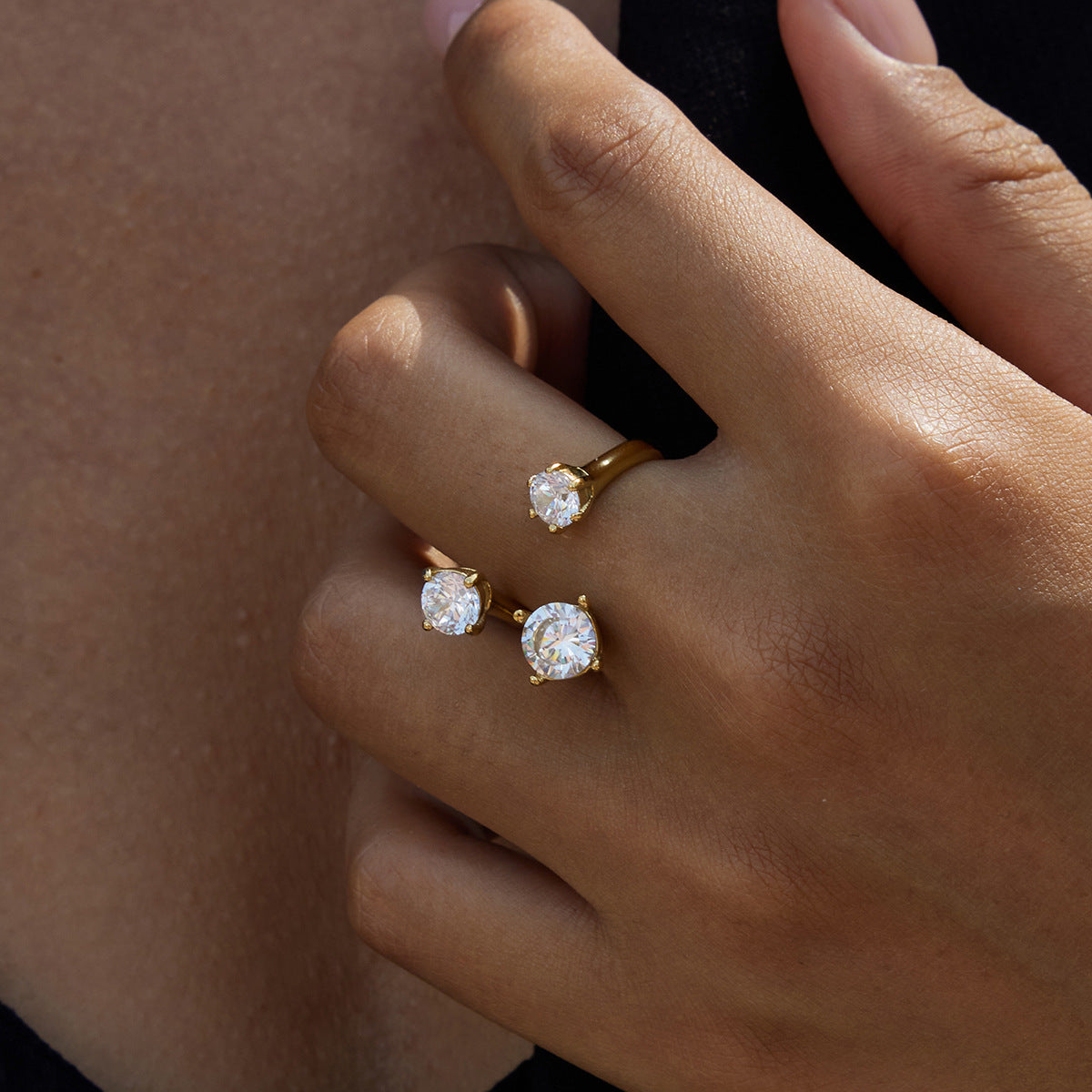 Adriana open crystal ring on a hand resting near the collarbone