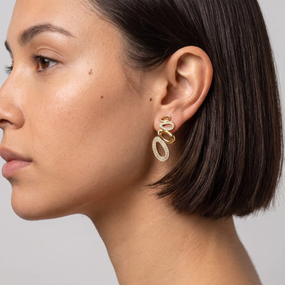 Woman wearing the Agathe pavé oval gold earrings on the ear in profile view