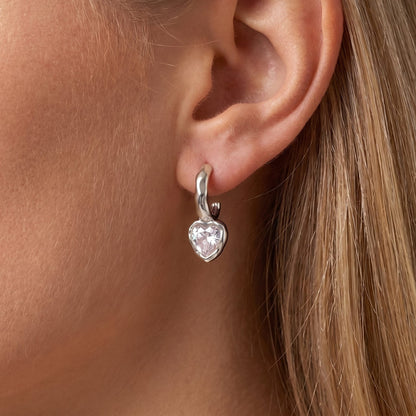 Woman wearing the Amandine hammered heart silver earrings on the ear
