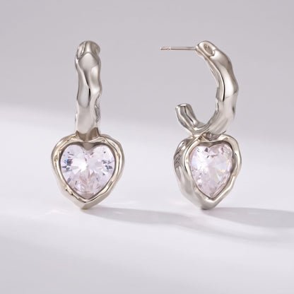 Amandine hammered heart silver earrings on a plain light background shown from front and side view