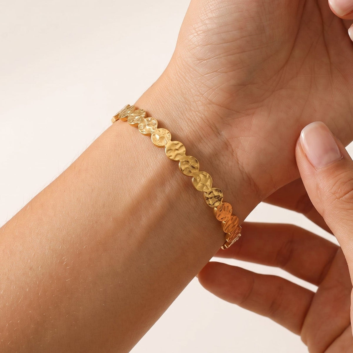 Woman wearing the Ambre hammered cuff gold bracelet on the wrist