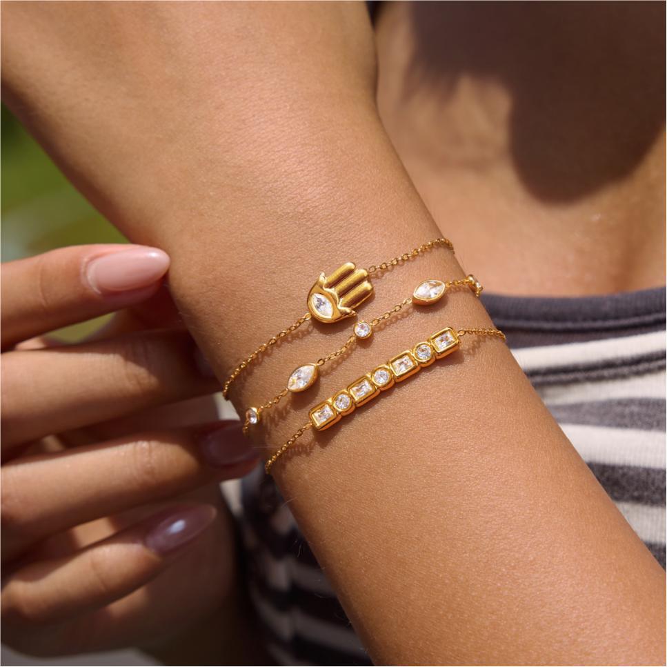 Amelia crystal hamsa bracelet worn highest in a stack of three on a sunlit wrist