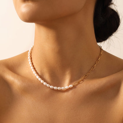 Close-up of a woman wearing the Amélie pearl paperclip gold necklace at the base of her neck