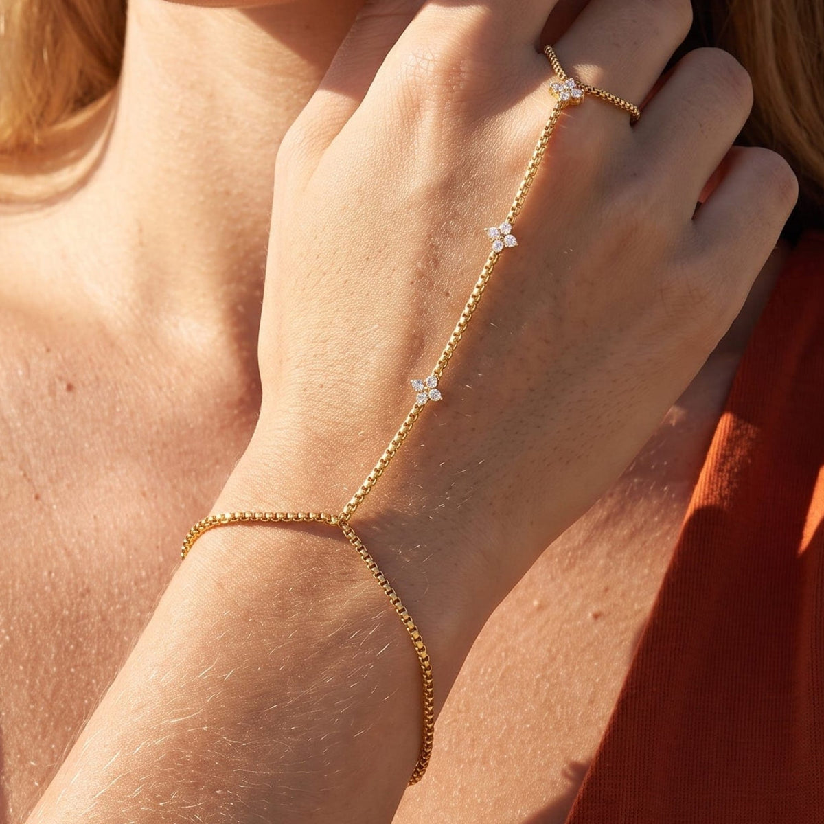 Woman wearing the Apolline hand chain gold bracelet on the hand