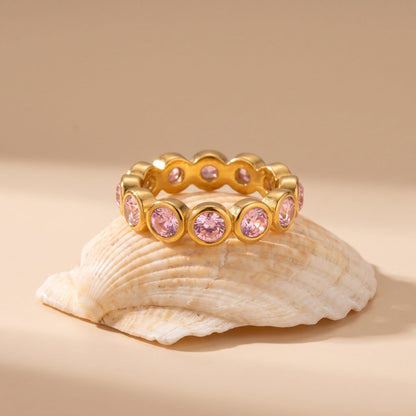Ariana pink round gold ring on a seashell with a neutral background