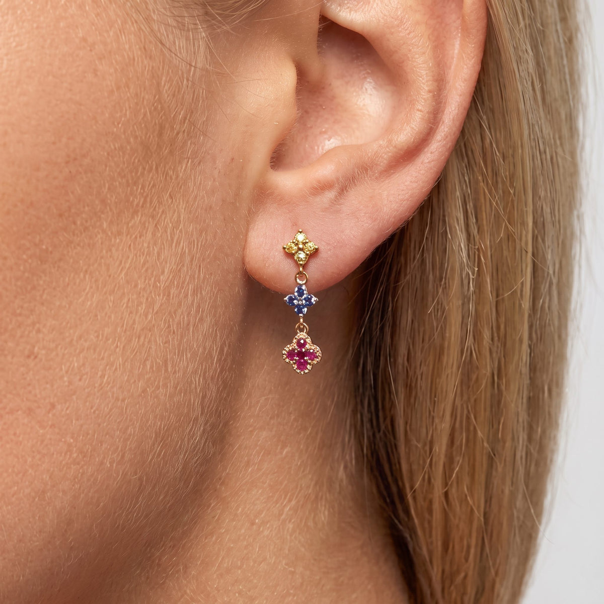 Woman wearing the Aurélie glimmer cluster earring with yellow, blue and pink crystal clovers