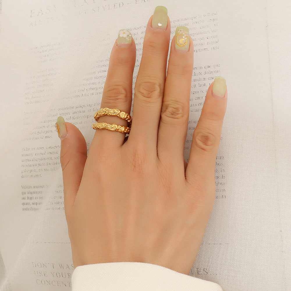 Woman's hand wearing the Aurélie hammered double gold ring on the index finger