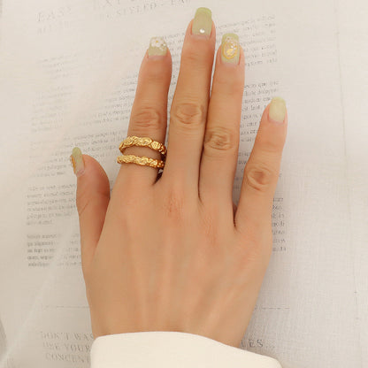 Woman's hand wearing the Aurélie hammered double gold ring on the index finger