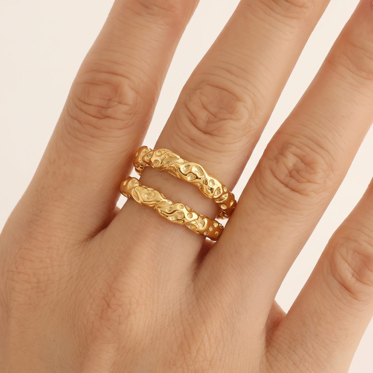 Close-up of the Aurélie hammered double gold ring worn on a ring finger
