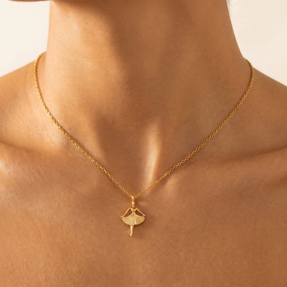 Woman wearing the Ava ballerina gold necklace at the collarbone