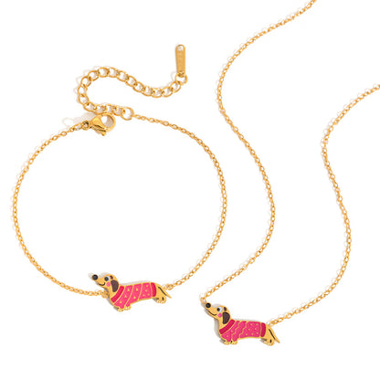 Bianca pink dachshund gold bracelet beside the matching necklace on a white background