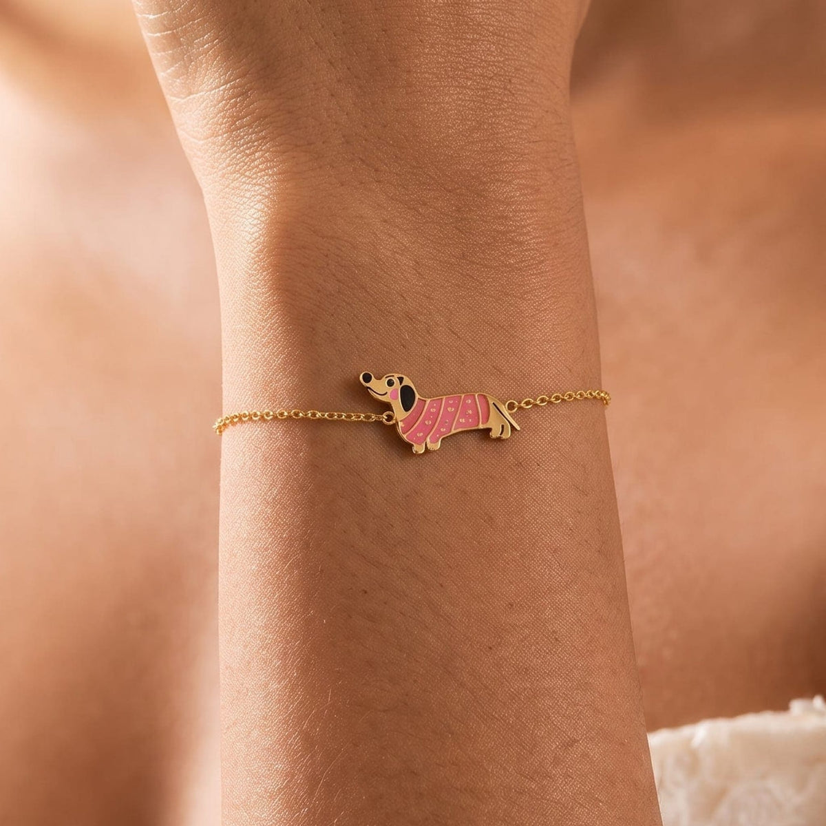 Woman wearing the Bianca pink dachshund gold bracelet on the wrist