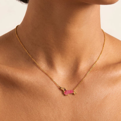 Woman wearing the Bianca pink dachshund gold necklace at the collarbone