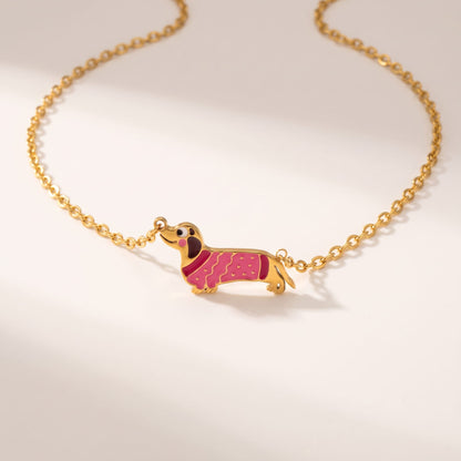 Bianca pink dachshund gold necklace on a white surface with gentle shadows