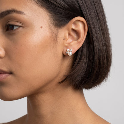 Woman wearing the Blanche pearl cluster gold earrings on her ear lobe with short dark hair
