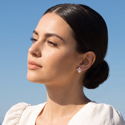 Woman wearing the Blanche pearl cluster gold earrings on her ear against a bright blue sky