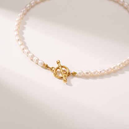 Camille pearl toggle gold necklace on a smooth beige surface