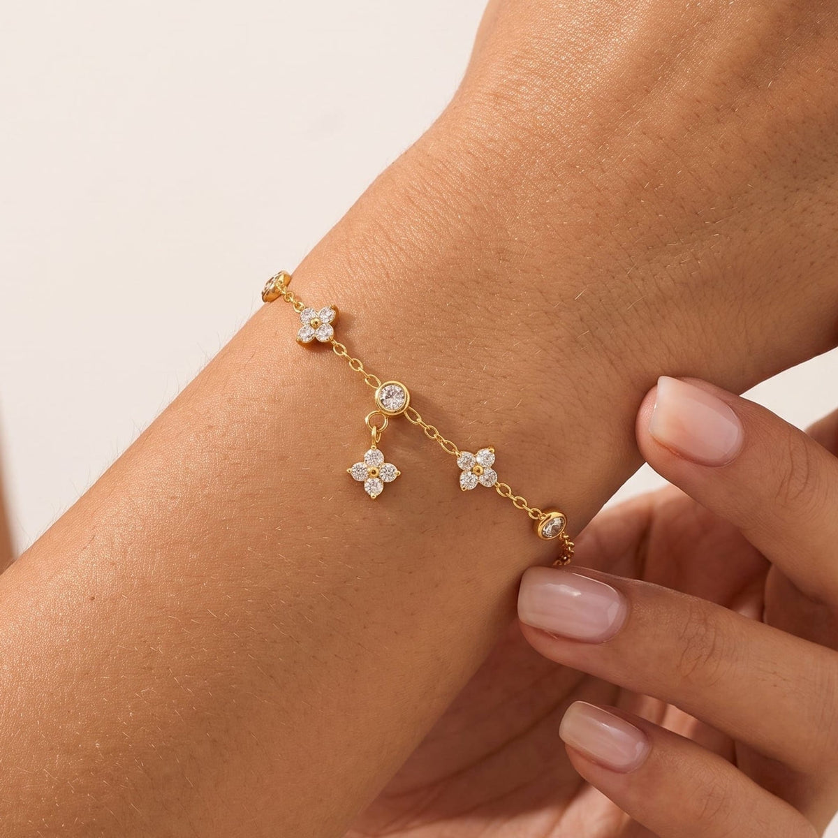 Woman wearing the Capucine clover drop gold bracelet on the wrist