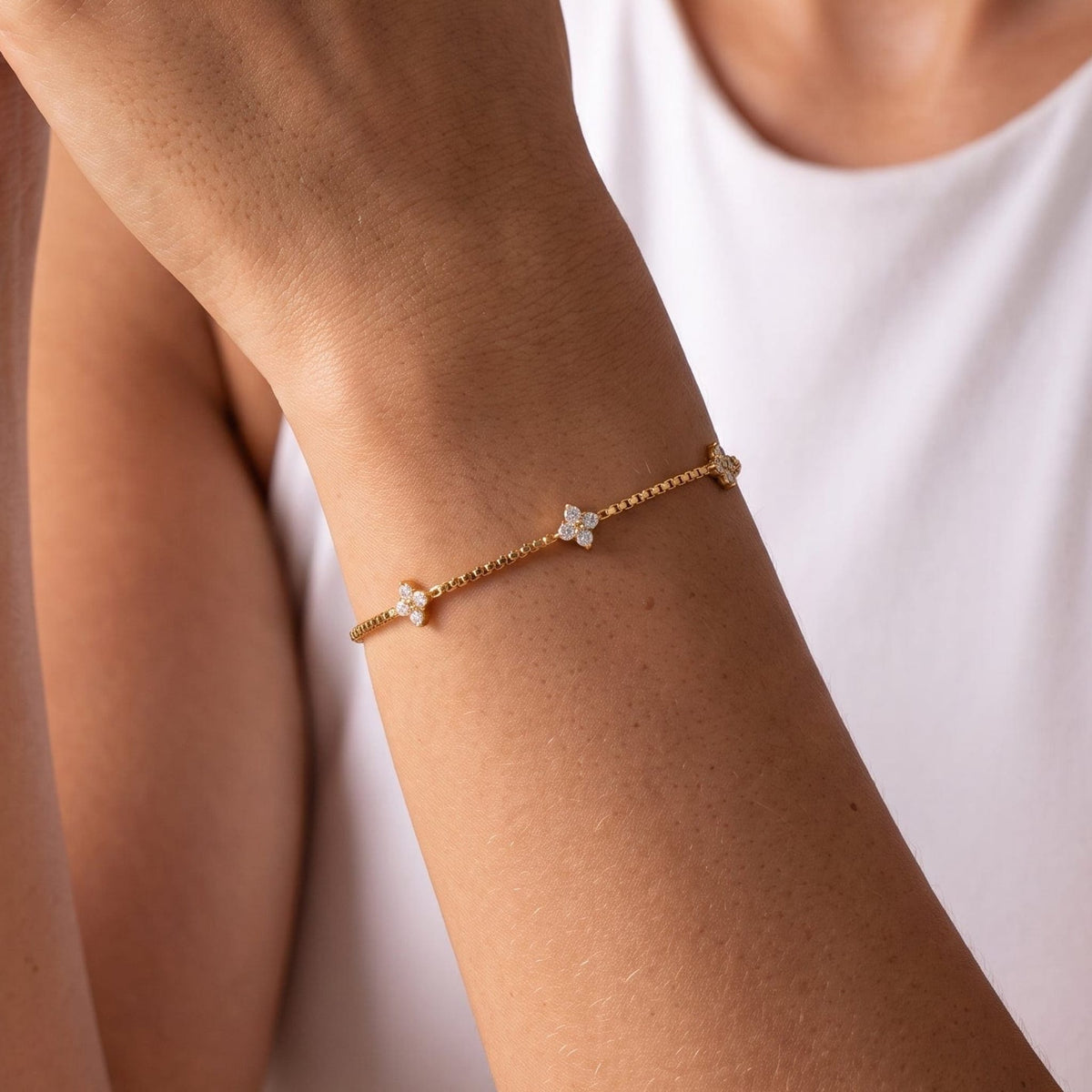 Woman wearing the Clara crystal clover gold bracelet on the wrist