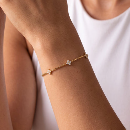 Woman wearing the Clara crystal clover gold bracelet on the wrist