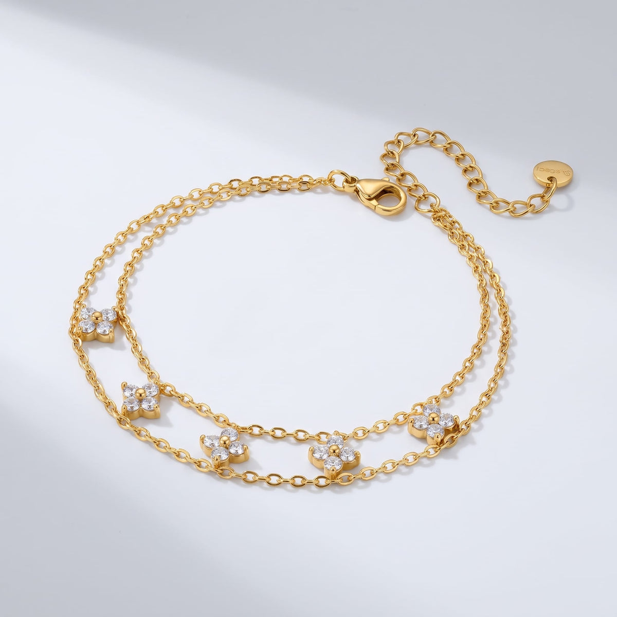 Clémence layered clover gold bracelet on a plain white surface showing chain details