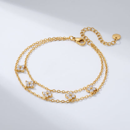 Clémence layered clover gold bracelet on a plain white surface showing chain details