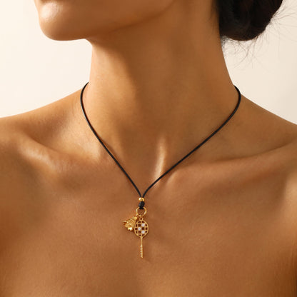 Close-up of a woman wearing the Colette badminton cord necklace at the base of her neck