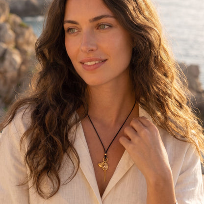 Woman by the sea at golden hour wearing the Colette badminton cord necklace