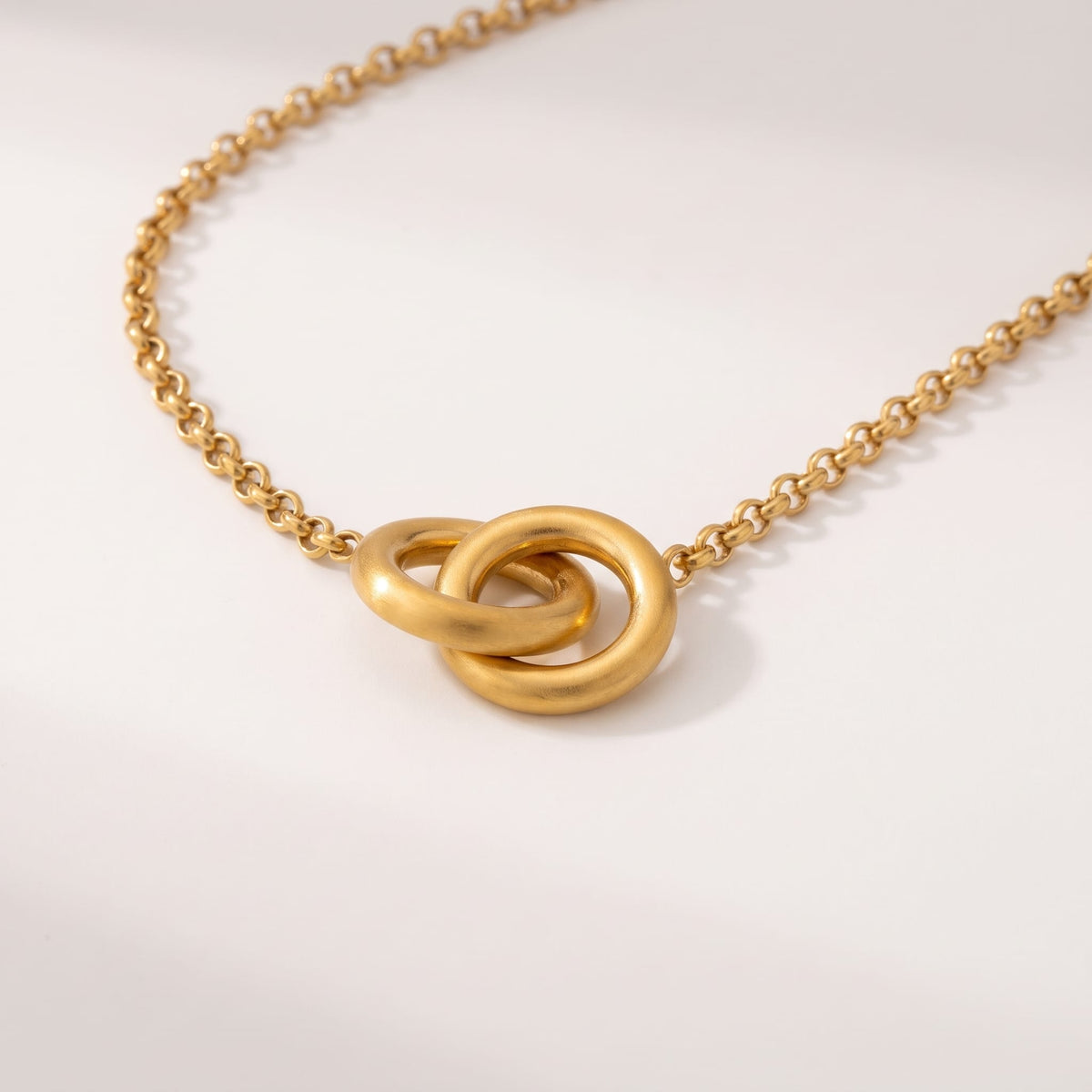 Colette interlocking rings gold necklace on a smooth white background showing chain detail
