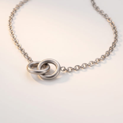 Colette interlocking rings silver necklace on a white surface with two interlocking circular pendant rings