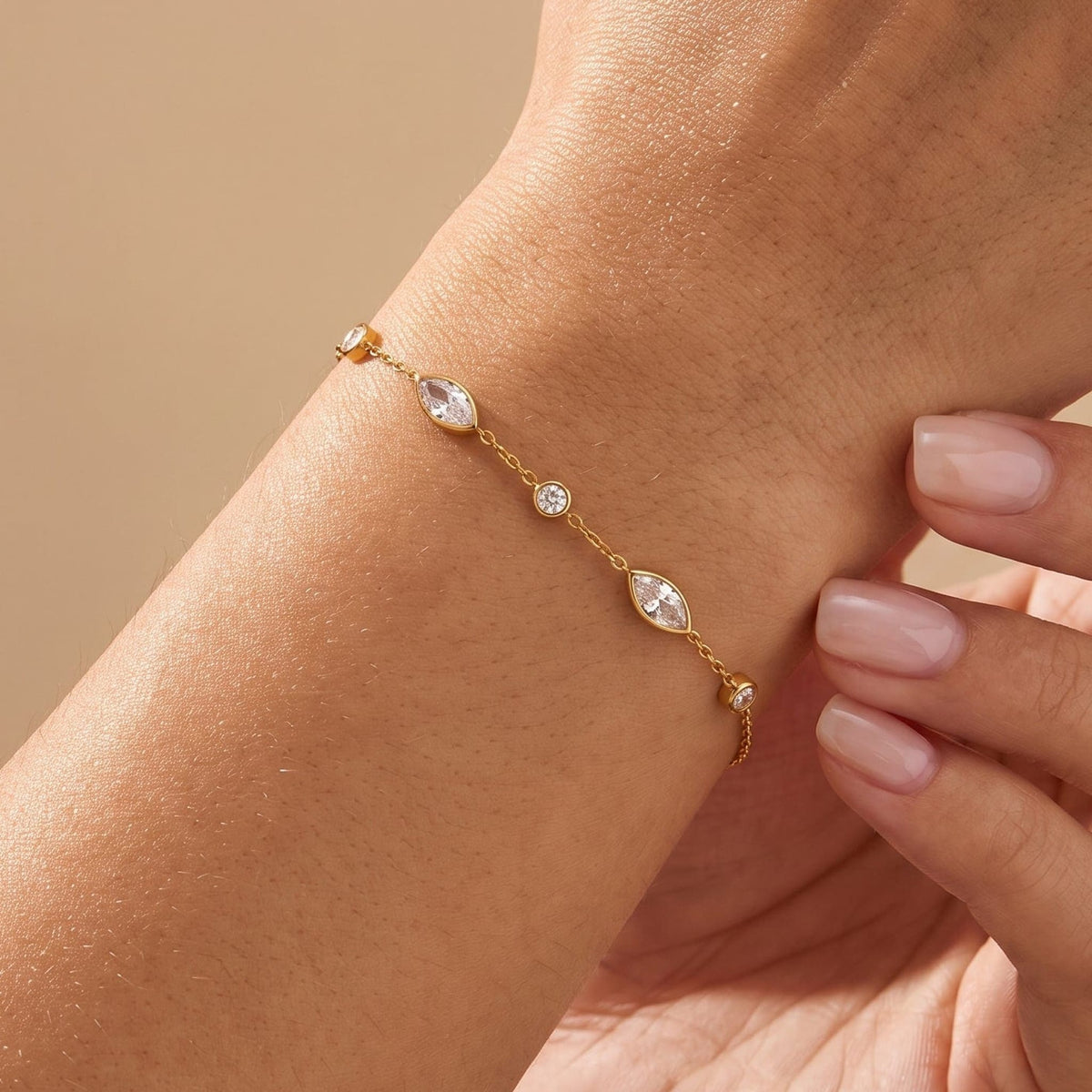Woman wearing the Cosima marquise station gold bracelet on the wrist