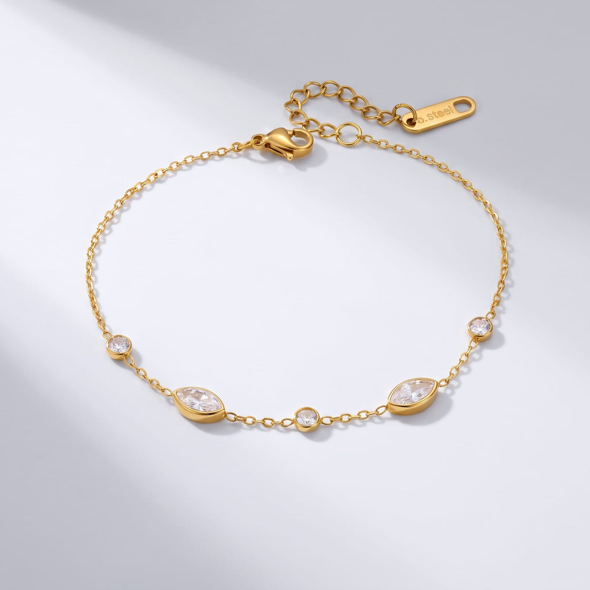 Cosima marquise station gold bracelet on a plain white surface with soft light